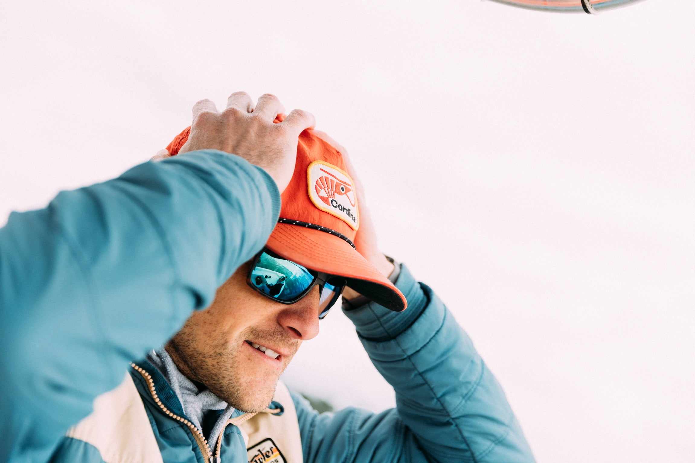 Man wearing red shrimp hat on the boat.